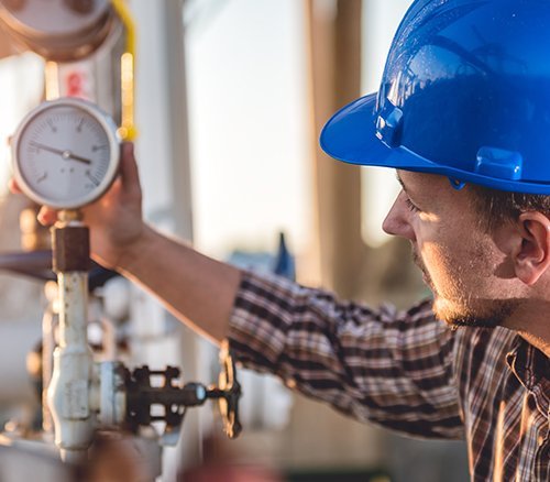 Ein Monteur der eine Gasleitung kontrolliert